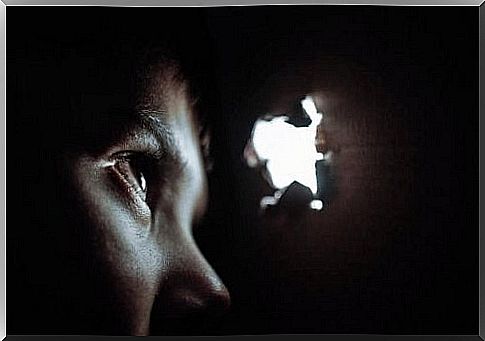 child peering through a hole