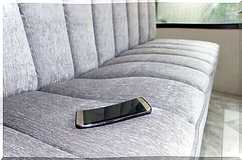 A cell phone lying on a sofa.